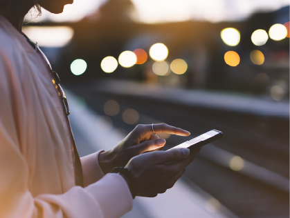 A woman using her phone for RSVP management, showing the ease of managing guest lists with online invitations.